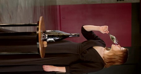 An elegant woman delights in sipping champagne while dressed in a sophisticated gown, fully embodying celebration