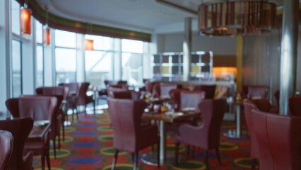 Blurred luxury restaurant interior with elegant red chairs, vibrant decor, and soft lighting conveying a sophisticated atmosphere.