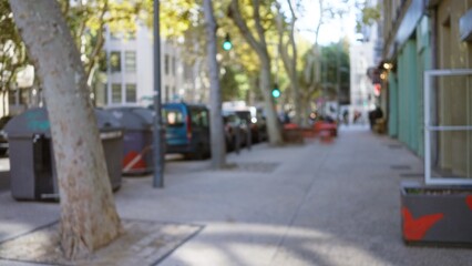 Blurred street scene in marseilles, france, with trees and parked cars under a clear sky, capturing an urban atmosphere with out of focus lighting and a sense of daily life.