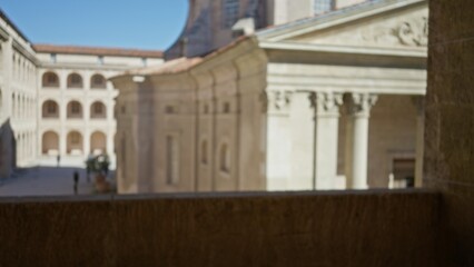 Obraz premium Blurred image of historic university campus outdoors featuring defocused, bokeh architecture with old stone buildings and sunny serene ambiance.