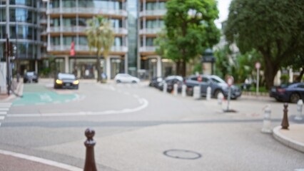 Defocused view of a luxury street in monaco with blurred cars and modern architecture under soft bokeh sunlight.
