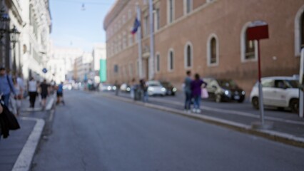 Blurred street view in rome featuring people walking along an old town road with historic buildings, capturing a defocused urban atmosphere in italy.