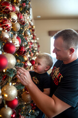 Dad and son decorating the Christmas tree . AI generative.