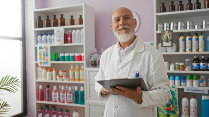 Man wearing a white coat holding a clipboard in a brightly lit pharmacy, with shelves of products...