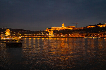 A photo of a boat is on the water near a bridge