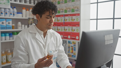 Hispanic pharmacist working with medicine in a drugstore at computer terminal