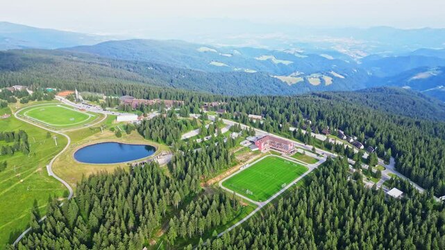Aerial view of beautiful mountain resort surrounded by tranquil forest and serene lake, Rogla, Slovenia.