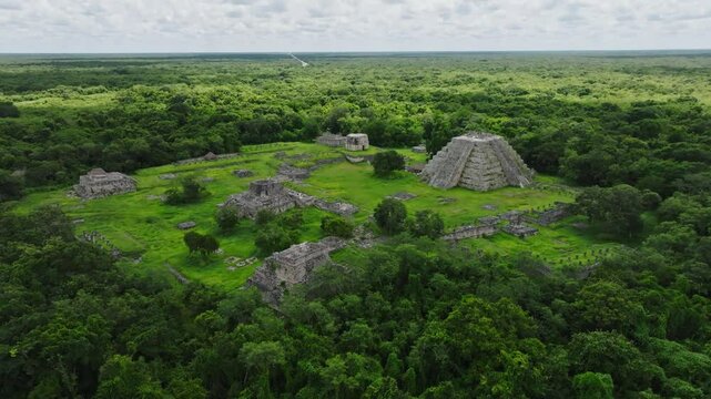 Aerial view of ancient maya ruins with a prominent temple and pyramid surrounded by lush greenery, Mayapan, Yucatan, Mexico.