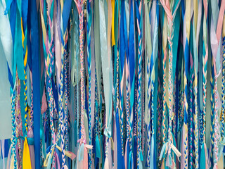 Background of braided multicolored pigtails made of ribbons
