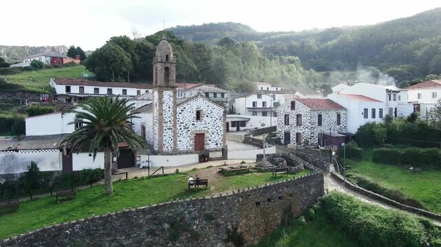 Aerial view of the picturesque village of San Andres de Teixido with a historic church surrounded by lush hills and tranquil forests, Cedeira, Spain.