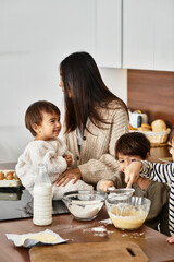 A happy Asian family enjoys baking in their modern kitchen, creating festive treats before...