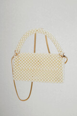 A pearl design bag completely covered with small white pearls with an elegant handle and gold...