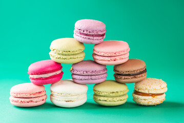Macarons in the form of a Christmas tree or pyramid with star on a green and red background.
