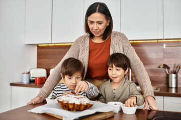 An Asian family enjoys a cheerful baking session, preparing holiday treats with children helping in the kitchen.