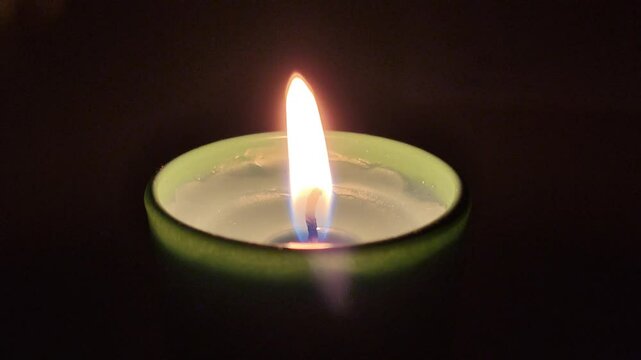 candlelight flame video. burning candle in green glass jar close up view thoughts and prayers condolence concept footage