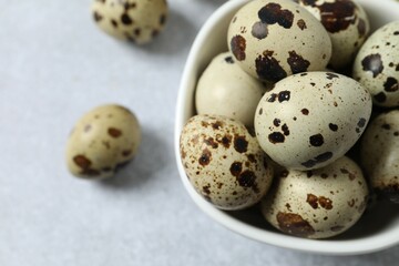 Obraz premium Quail eggs in a plate on gray background 