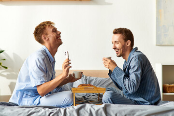 A happy couple shares a cozy morning in pajamas, sipping coffee and enjoying each others company.
