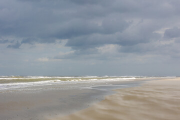 Landscape view of wide and long sand beach on the Dutch Wadden sea under cloudy sky, Schiermonnikoog is a municipality and national park in the Northern Netherlands and one of the West Frisian Islands