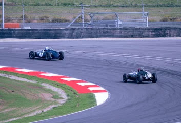  Two historical formula cars are driving fast on a corner during a race on the track © Jonatan