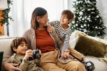 A grandmother smiles as her grandchildren play and enjoy the Christmas spirit at home.