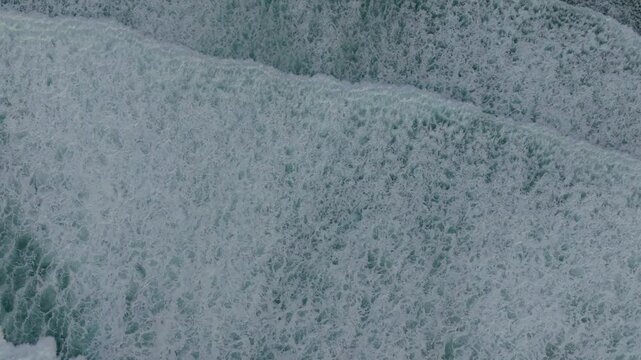 Drone shot of Foamy Sea Waves On The Beach In Caion, A Laracha, Spain