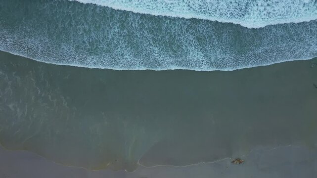 Drone shot of Foamy Sea Waves On Thesandy  Beach In Caion, A Laracha, Spain
