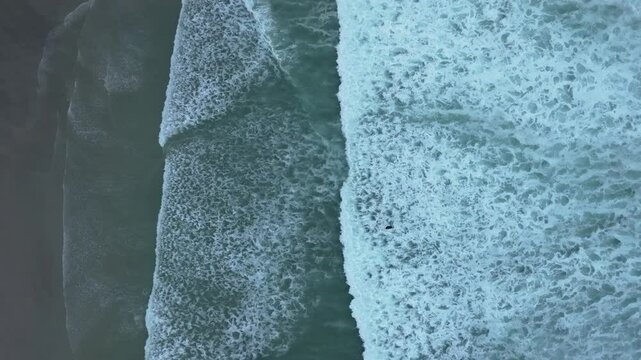 Drone shot of Foamy Sea Waves On Thesandy  Beach In Caion, A Laracha, Spain