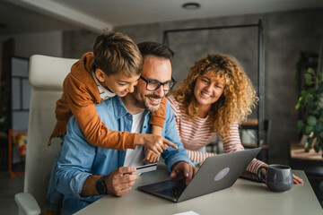 family of 3 have online shopping on laptop with credit card