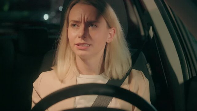 Nervous worried stressed Caucasian woman female girl automobile driver stopped by police emergency light siren steering wheel alcohol drunk driving traffic accident arrest inside car auto night late