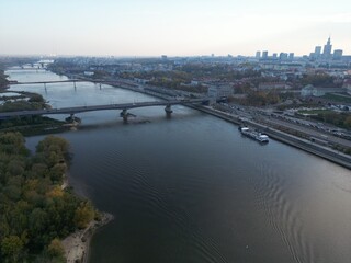 Fototapeta premium Aerial View of River with Bridges in Large City with Skyscrapers on Horizon