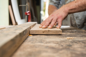 A carpenter is milling a board on a homemade machine