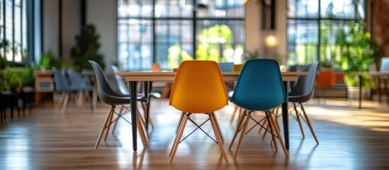 Colorful chairs around wooden table in modern office space.