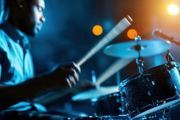 Drummer playing intensively under vibrant stage lights.
