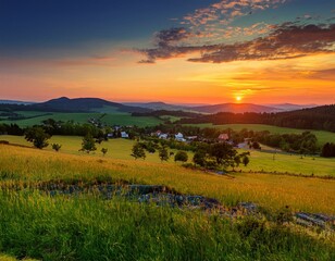 Obraz premium Picturesque sunset in Beskid Sądecki seen from the tower in Wola Krogulecka, with views of the mountains and fields.