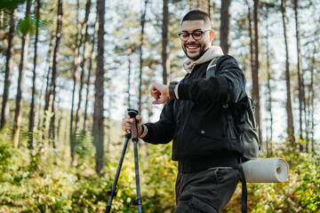 Young caucasian man hiking or trekking through the forest	