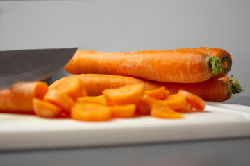 close-up of carrots lying on a white board