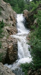Fototapeta premium Cascading Waterfall Over Rocky Terrain