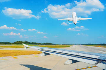 Wing view of the turn from the taxiway onto the runway and passenger jet plane gaining altitude...
