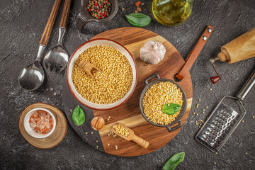 Raw ptitim pasta on a dark background. top view. copy space for text