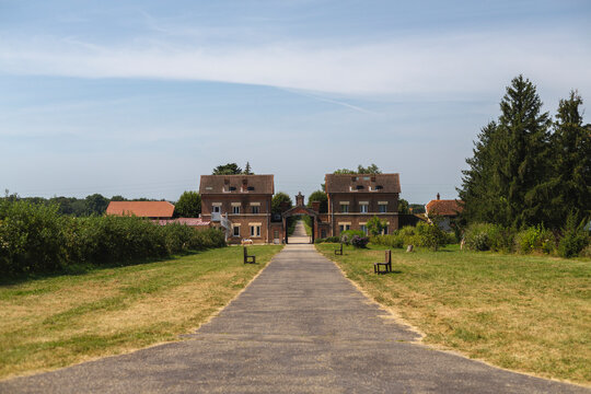 View of the abbey of our lady of dombes surrounded by trees and grass in a peaceful rural landscape, Le Plantay, France.