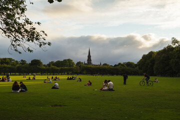 Edinburgh, Scotland - 05 August 2024: View of a peaceful park with people socializing and relaxing under trees, Edinburgh, Scotland.