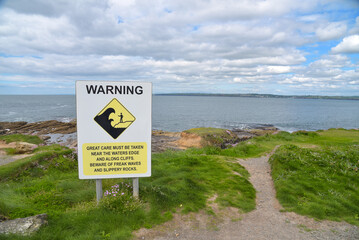 Landschaft mit Warnschild an der Küste von Irland