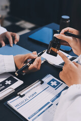 Confident representative pharmaceutical showing new medicines to a team of doctor and nurse in hospital. Mature specialist man showing bottle of pills and explaining drug dosage to a group of doctors.