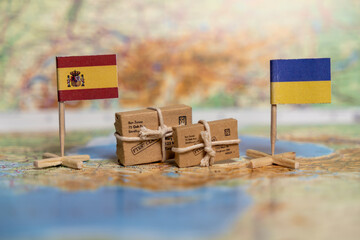 Humanitarian Aid Exchange Between Spain and Ukraine Symbolized by National Flags and Parcels on...