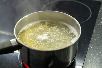 Boiling water on the kitchen stove. Cooking food in the kitchen