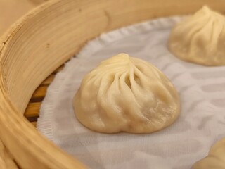 Xiao long bao in bamboo steaming basket. Steamed pork soup dumpling. Chinese steam bun. Chinese food menu