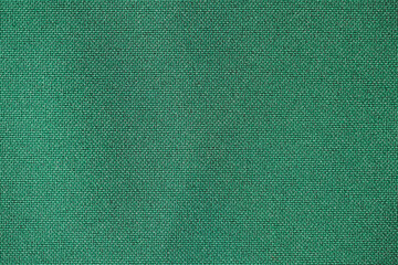 High-quality texture of rich royal green fabric with a soft and luxurious feel. This deep green material features a smooth, perfect for backgrounds, textiles, wallpapers