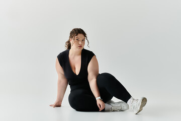 A stylish plus size woman confidently poses against a light backdrop.