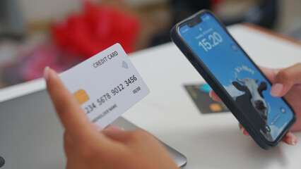 A woman registers using a credit card on her laptop, making a secure online payment for a home...