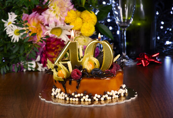 Caramel birthday cake with candles number forty stock photo images. Chocolate birthday cake with candles number forty and bouquet close-up stock photo images